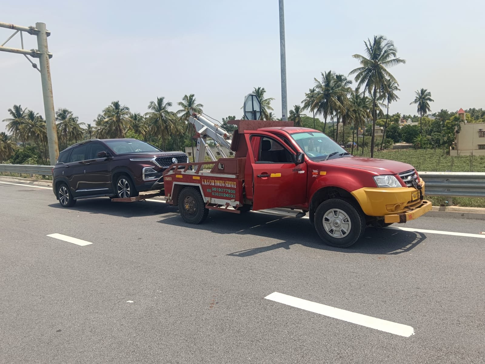 G.M.G tow truck hitched to a car for towing in Bengaluru