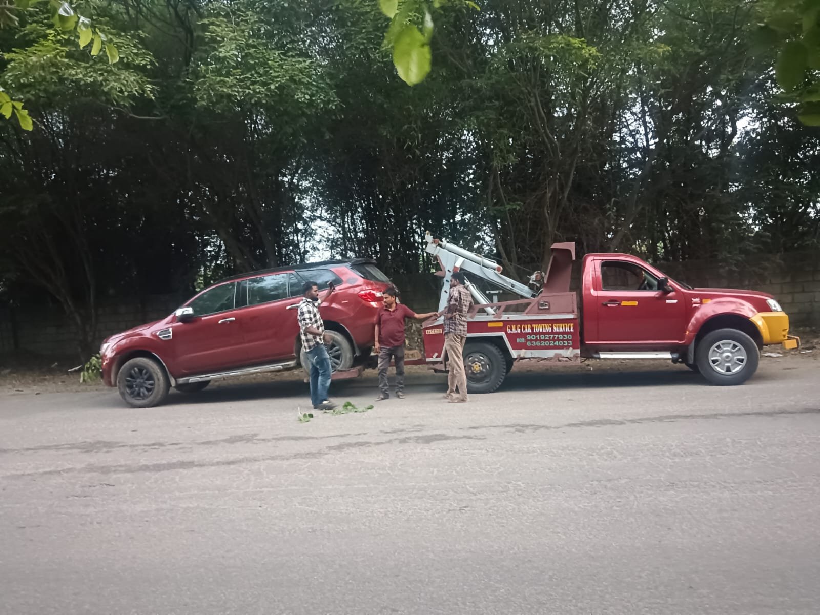 G.M.G towing crew and truck at work