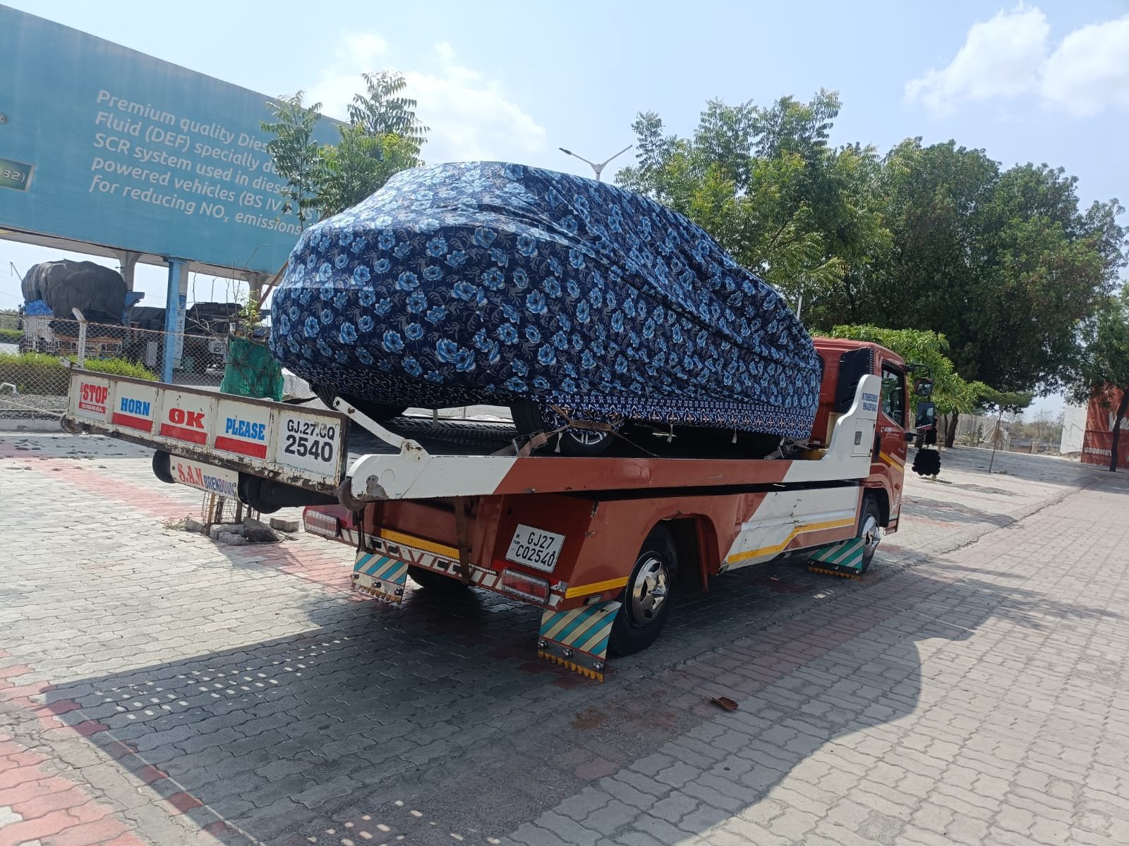 Flatbed towing truck carrying a vehicle